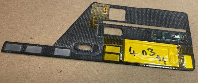 This ultra thin and flexible "deep insert" skimmer recently recovered from an NCR cash machine in New York is about half the height of a U.S. dime. The large yellow rectangle is a battery. Image: KrebsOnSecurity.com.